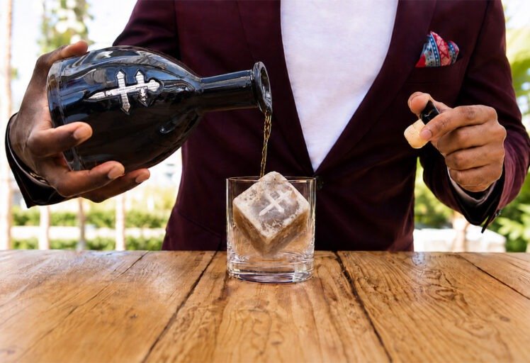 Bartender pouring D’USSÉ XO over a Coffee Uplifts People Café Con Leche coffee ice cube, creating a coffee-and-cognac beverage experience.
