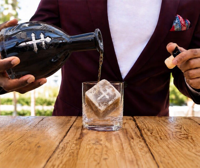 Bartender pouring D’USSÉ XO over a Coffee Uplifts People Café Con Leche coffee ice cube, creating a coffee-and-cognac beverage experience.