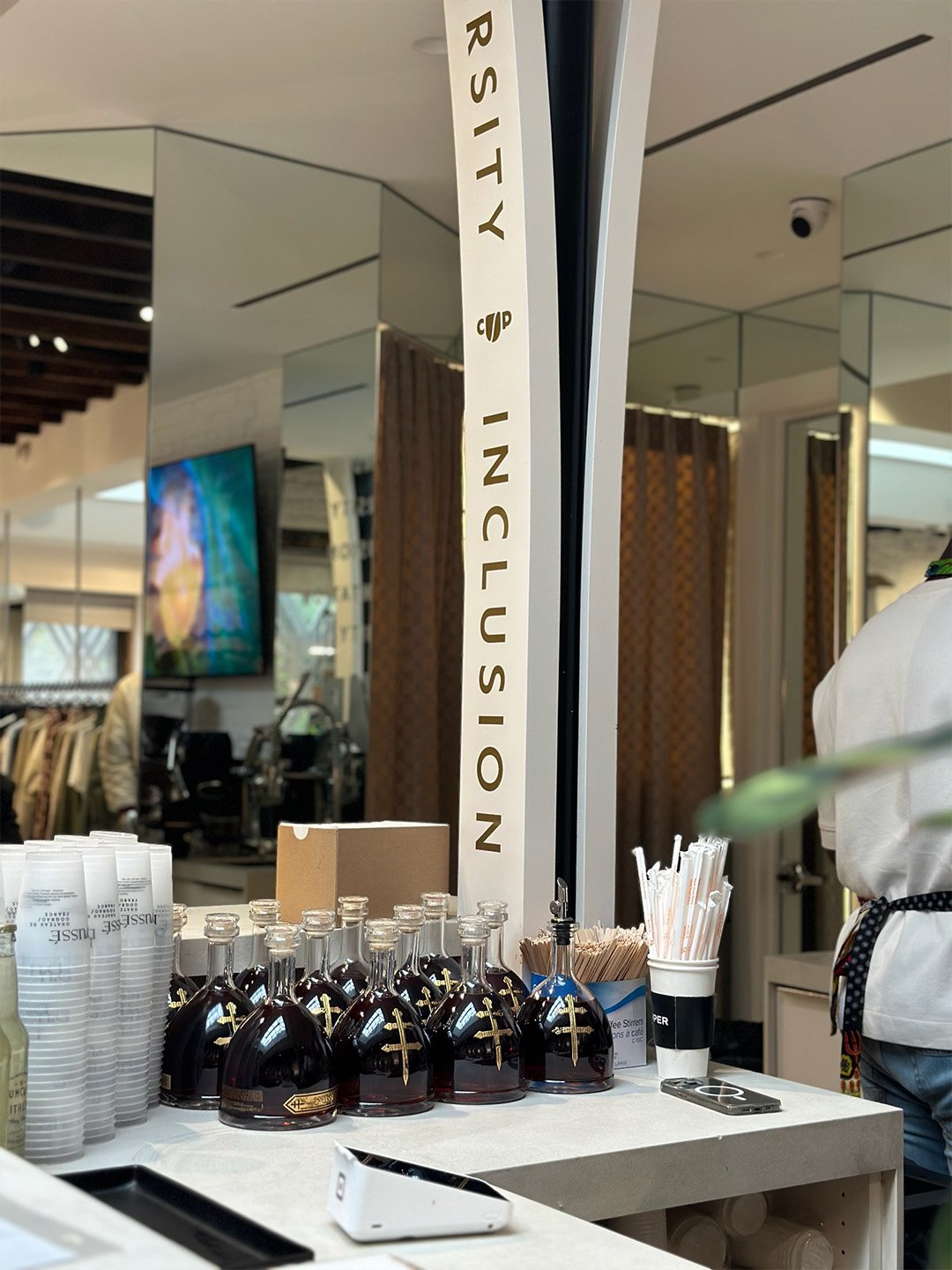 D’USSÉ bottles displayed inside the Coffee Uplifts People activation at Daily Paper NYC beside CUP diversity, inclusion and representation environmental graphics.