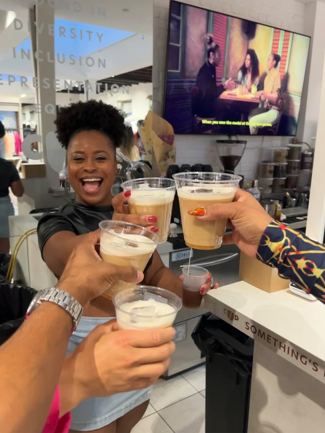 Guests toasting Coffee Uplifts People coffee drinks during the D’USSÉ x CUP Paper CUP Friday activation in New York.