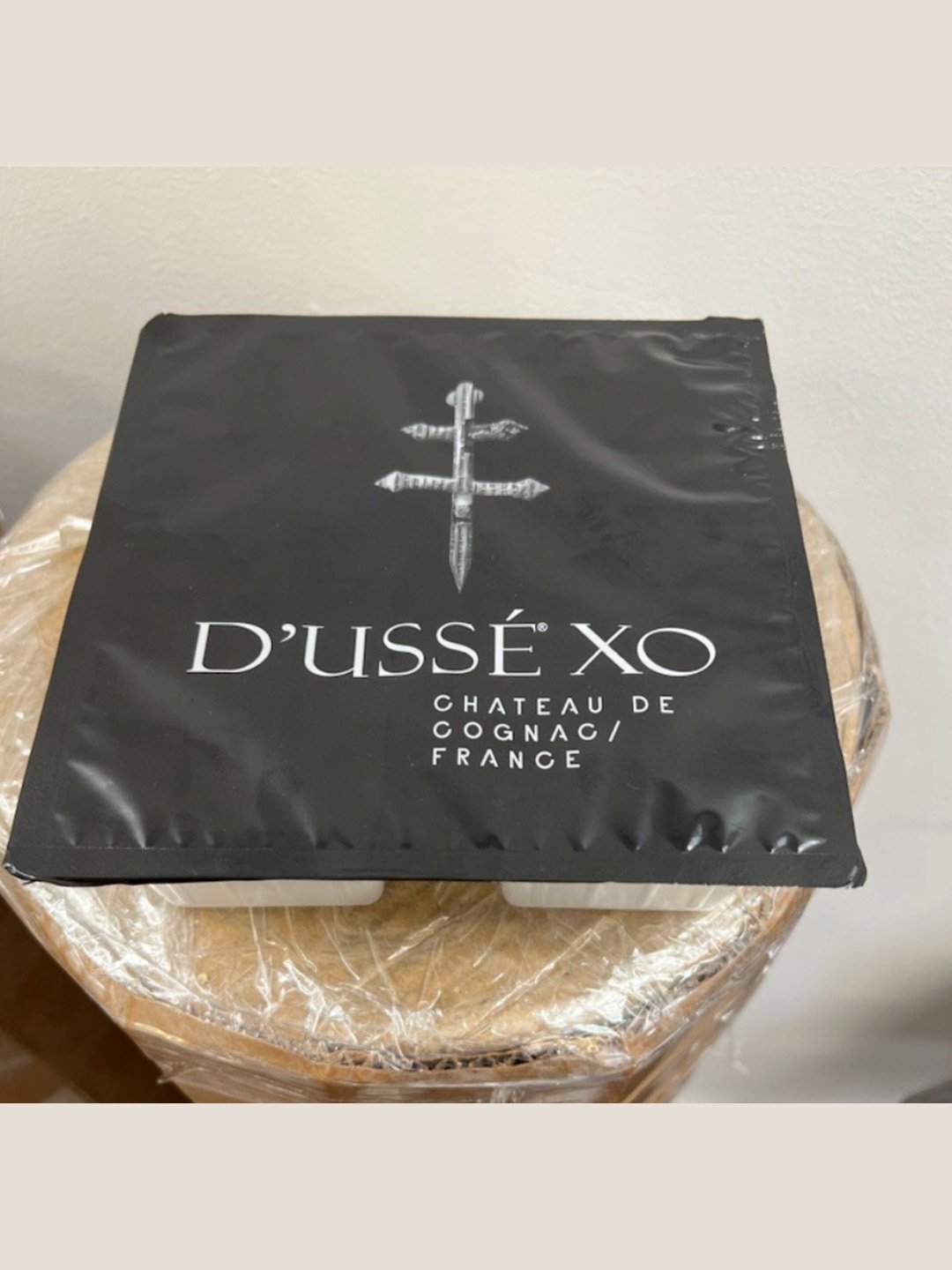 Black D’USSÉ XO branded package containing frozen coffee cubes prepared for the D’USSÉ x Coffee Uplifts People beverage program.